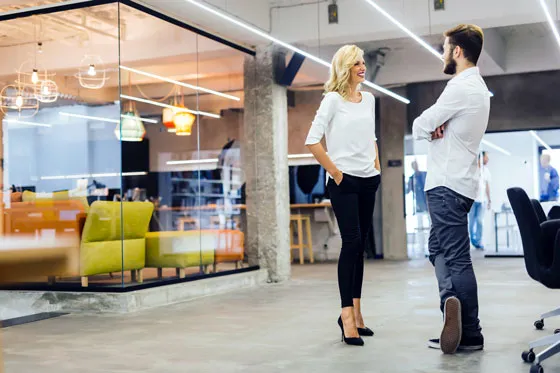 Zwei Kollegen im Gespräch in einem modernen Büro